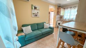 sala de estar con sofá verde y cocina en Buriana Beach, en Nerja