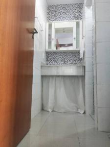 a white bathroom with a sink and a mirror at Alta Domus in Brusque