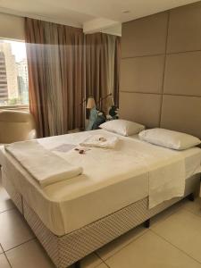 uma cama grande num quarto de hotel com uma janela em Suite Queen Deluxe BH em Belo Horizonte