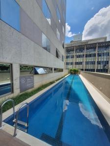 uma grande piscina ao lado de um edifício em Suite Queen Deluxe BH em Belo Horizonte