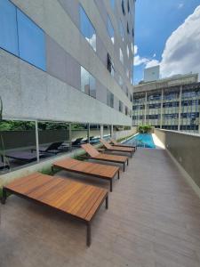 a row of benches on the roof of a building at Suite Queen Deluxe BH in Belo Horizonte