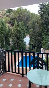 貝瑙漢的住宿－APARTAMENTO RIBERA DEL GUADIARO, 14，阳台配有桌椅,享有泳池美景