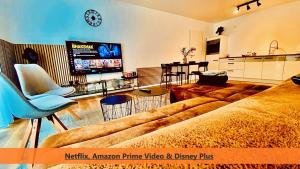 Better Living - Villa - Exklusiv Studio 76qm في مونتابور: غرفة معيشة مع أريكة وتلفزيون