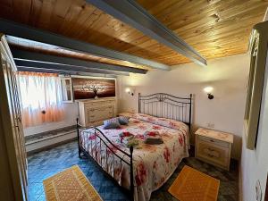 a bedroom with a bed and a wooden ceiling at La Bomboniera in Bari Sardo