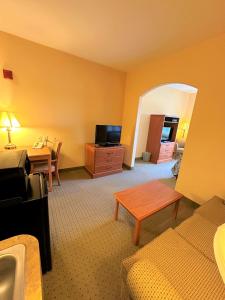 a hotel room with a bed and a table and a desk at Super 8 by Wyndham Topeka at Forbes Landing in Topeka