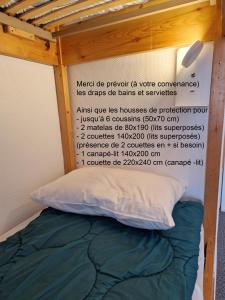 uma cama com um sinal ao lado em Studio Moderne au pied des pistes 4 Pers - La Pierre Saint-Martin GR10 em Arette