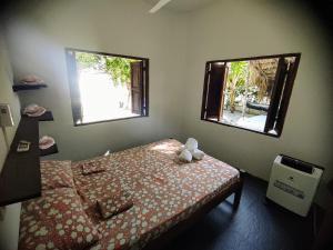 a small bedroom with a bed and two windows at La Caracola Cartagena in Cartagena de Indias