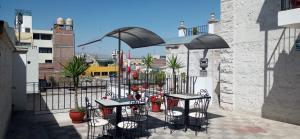 a patio with tables and chairs on a balcony at Hotel Mutua FAP in Arequipa