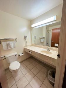 uma casa de banho com um WC, um lavatório e um espelho. em Super 8 by Wyndham Topeka at Forbes Landing em Topeka