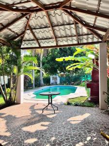 un patio con una mesa frente a la piscina en Casa en Condominios San Blas 5 minutos del Tunco, en La Libertad