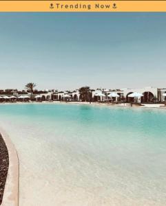a large pool with blue water in a resort at Le Sidi Cabana ( hacienda bay ) in El Alamein