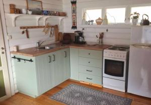 a kitchen with white cabinets and a sink and a stove at Hytte ved Preikestolen in Forsand +20 photos
