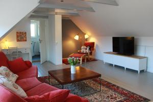 a living room with a red couch and a tv at Bjerred B&B in Bjärred