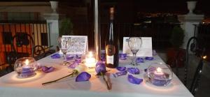 a table with purple flowers and candles and wine glasses at Hotel Mutua FAP in Arequipa