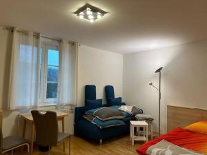 1 dormitorio con sofá azul, escritorio y cama en Ferienwohnung am Labyrinth, en Semriach