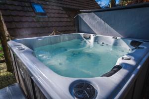 een bad gevuld met blauw water in een achtertuin bij Wellnesshuis met jacuzzi en sauna in het bos in Lunteren