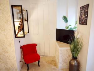 - Silla roja en la sala de estar con espejo en Cosy Claudel, en Nogent-sur-Seine