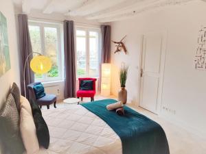 1 dormitorio con 1 cama grande y 2 sillas en Cosy Claudel, en Nogent-sur-Seine