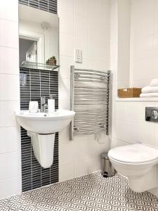 a white bathroom with a sink and a toilet at City Centre Apartment Near the University and Bodleian Library in Oxford