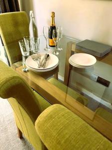 een glazen tafel met een bord en wijnglazen bij COLE HOUSE in Solihull