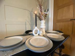 un tavolo con quattro piatti e una candela sopra di A spacious home from home with spectacular views a Heywood