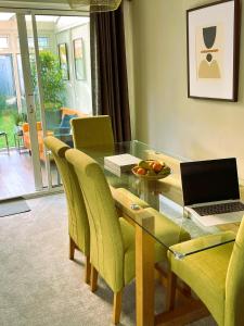a dining room with a glass table with a laptop on it at COLE HOUSE in Solihull