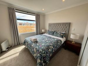 a bedroom with a bed and a large window at Whiti Te Ra 1 Bed in Lake Tekapo