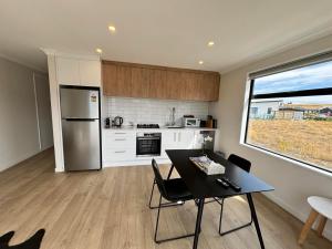 a kitchen with a table and a refrigerator at Whiti Te Ra 1 Bed in Lake Tekapo