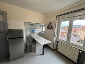eine kleine Küche mit einem Schreibtisch und einem Fenster in der Unterkunft T3 Premium - Calme & spacieux 6-12 personnes in Belfort