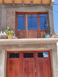 ein Paar Holztüren auf einem Gebäude in der Unterkunft susurros del viento in Tilcara