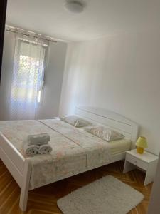 ein weißes Schlafzimmer mit einem Bett mit Handtüchern darauf in der Unterkunft Sea Star in Split