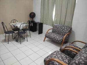 salon ze stołem i krzesłami w obiekcie Apartamento inteiro no Bairro Alto Umuarama w mieście Uberlândia