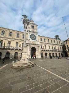 a building with a clock tower and a statue in front of it at San Clemente guest house in Padova