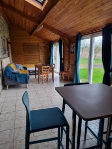 ein Wohnzimmer mit einem Tisch, Stühlen und einem Sofa in der Unterkunft Maison de famille in Pré-en-Pail