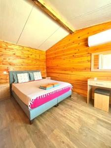 a bedroom with a bed in a room with wooden walls at Adrasan Yıldız Bungalow Tatil Köyü in Adrasan