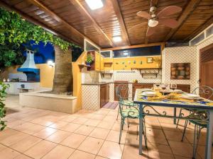 a kitchen with a table with chairs and a ceiling fan at Villa Candiano in Sampieri