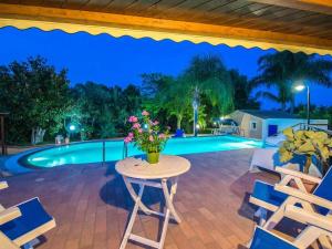 a patio with a table and chairs and a pool at Villa Candiano in Sampieri