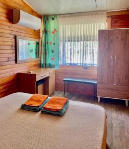 1 dormitorio con 1 cama con 2 toallas en Adrasan Yıldız Bungalow Tatil Köyü, en Adrasan