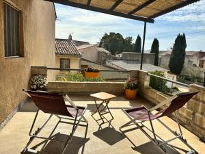 a patio with chairs and a table on a balcony at Maison de village -Luberon - Villelaure in Villelaure