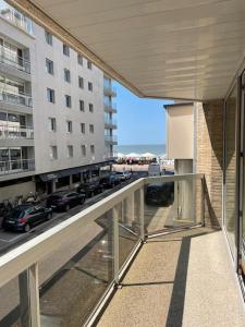 ein Balkon mit Blick auf einen Parkplatz in der Unterkunft Mooi appartement met zijdelings zeezicht, op 100 meter van strand in Knokke-Heist