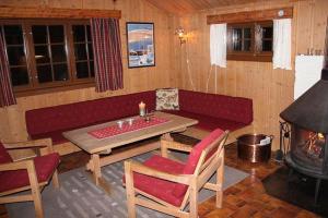 ein Wohnzimmer mit einem Sofa, einem Tisch und einem Kamin in der Unterkunft Trevet by Norgesbooking - cabin close to skicenter in Holo