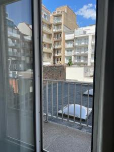 Blick aus einem Balkonfenster auf Gebäude in der Unterkunft Mooi appartement met zijdelings zeezicht, op 100 meter van strand in Knokke-Heist + 2 Fotos
