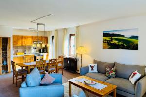 ein Wohnzimmer mit einem Sofa und einem Tisch in der Unterkunft Ferienwohnung Lotti + Hochschwarzwald Card in Titisee-Neustadt