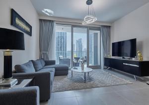- un salon avec un canapé et une télévision dans l'établissement Majestic Forte2 17th- Burj khalifa & Fountain view, à Dubaï