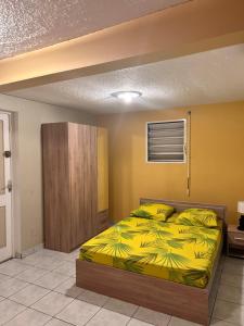 a bedroom with a bed with a yellow blanket at La Maison Cocktail in Émilien