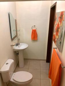 a bathroom with a white toilet and a sink at Habitación Doble Mayan Plaza in Copan Ruinas