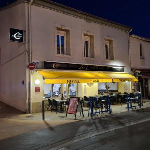 um restaurante com mesas e cadeiras em frente a um edifício em LE CENTRAL HOTEL BAR RESTAURANT em Balaruc-les-Bains