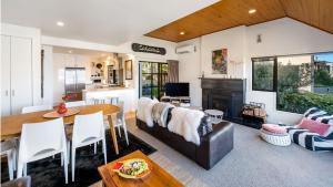 ein Wohnzimmer mit Sofa und Tisch in der Unterkunft Villa Tuke- Free Parking- Fire Place in Queenstown