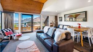 ein Wohnzimmer mit einem Sofa und einem Tisch sowie ein Esszimmer in der Unterkunft Villa Tuke- Free Parking- Fire Place in Queenstown