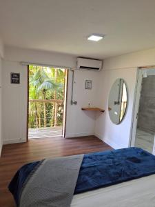 Schlafzimmer mit einem Bett und einem Wandspiegel in der Unterkunft Down The River Hostel in Iporanga